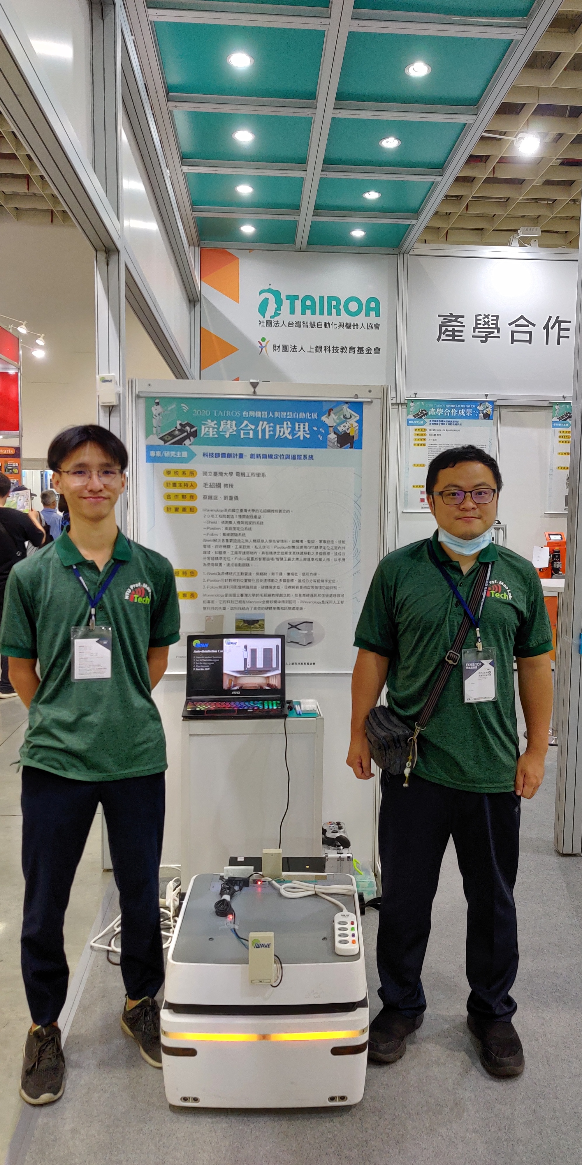 two men and an autonomous disinfection robot during an exhibition in Taipei